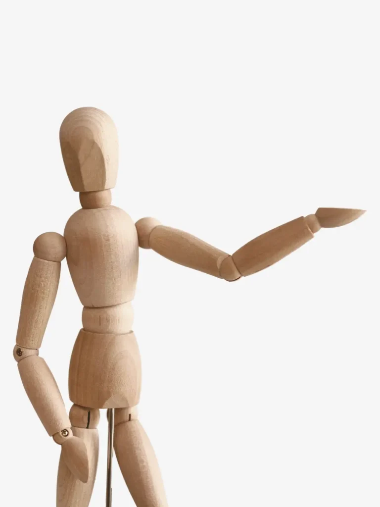 Gliederpuppe aus Holz, die einen Arm seitlich ausstreckt und nach rechts zeigt
